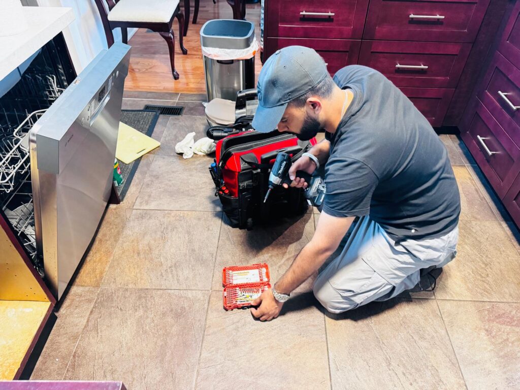Appliance repair technician repairing a dishwasher in Brampton