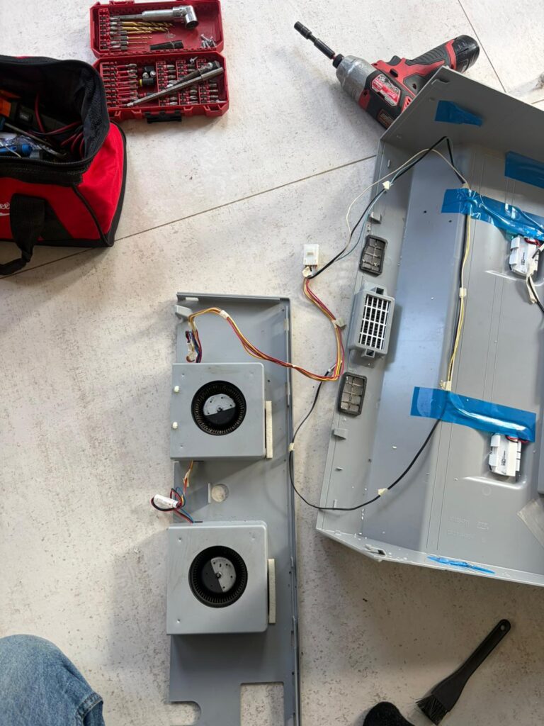 Disassembled appliance components and wiring during professional appliance repair