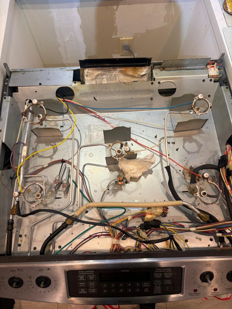 Gas range oven repair with internal components exposed for diagnosis
