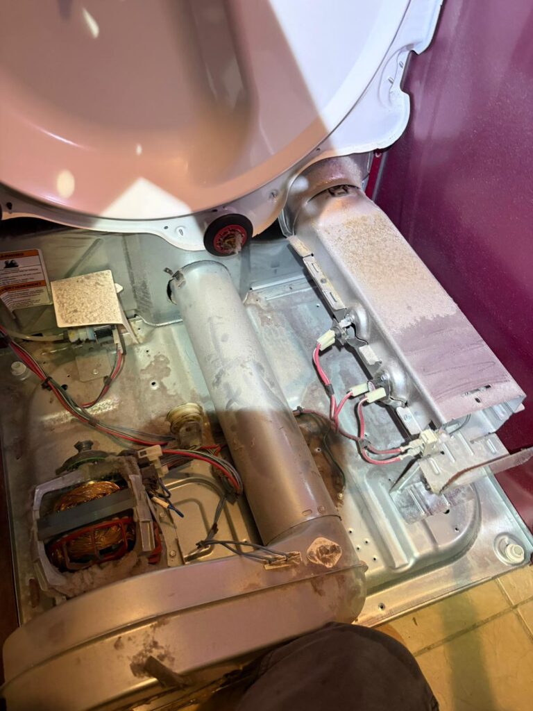 Disassembled clothes dryer being inspected for internal repair